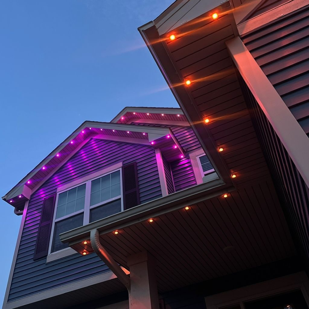Close-up of purple and warm permanent LED lights along a roofline