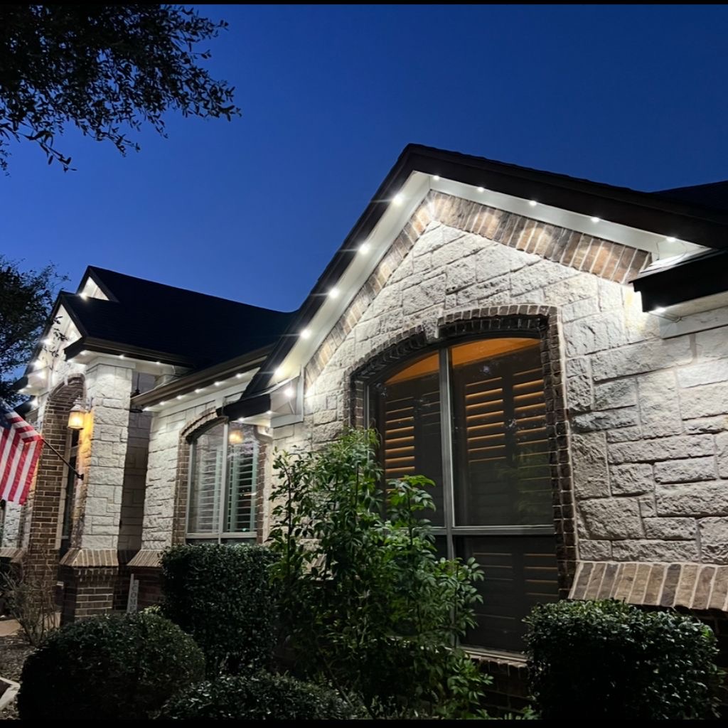 Stone home with clean white permanent LED trim lighting at dusk